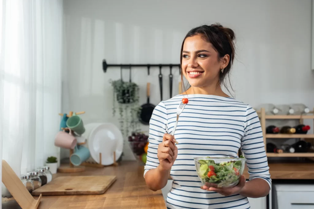 caucasian young woman eating healthy green salad i utc